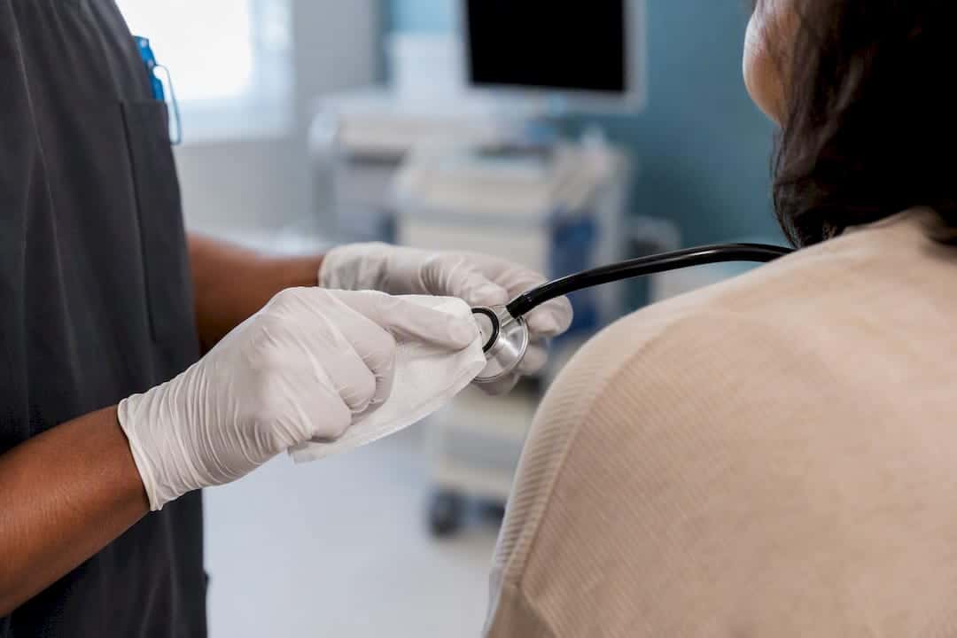 Gloved hands wiping blood pressure cuff