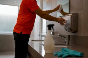 Janitor cleaning office restroom fixture