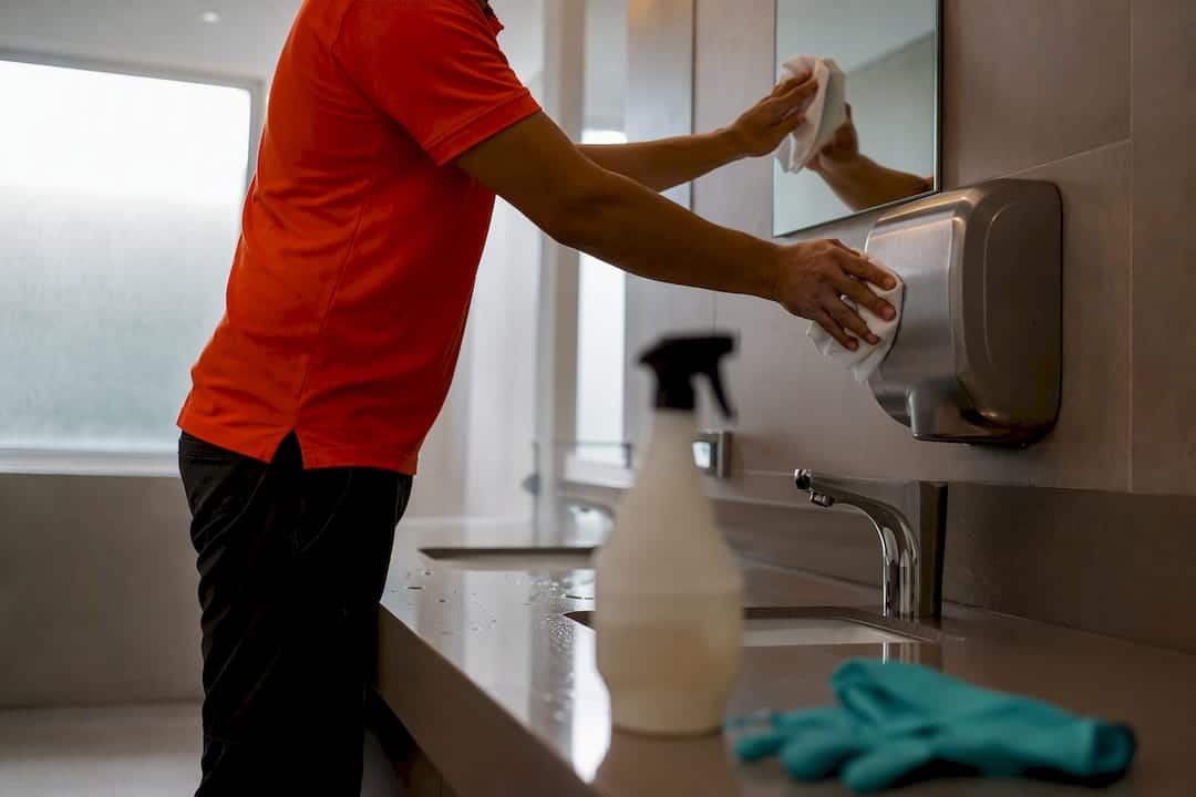 Janitor cleaning office restroom fixture