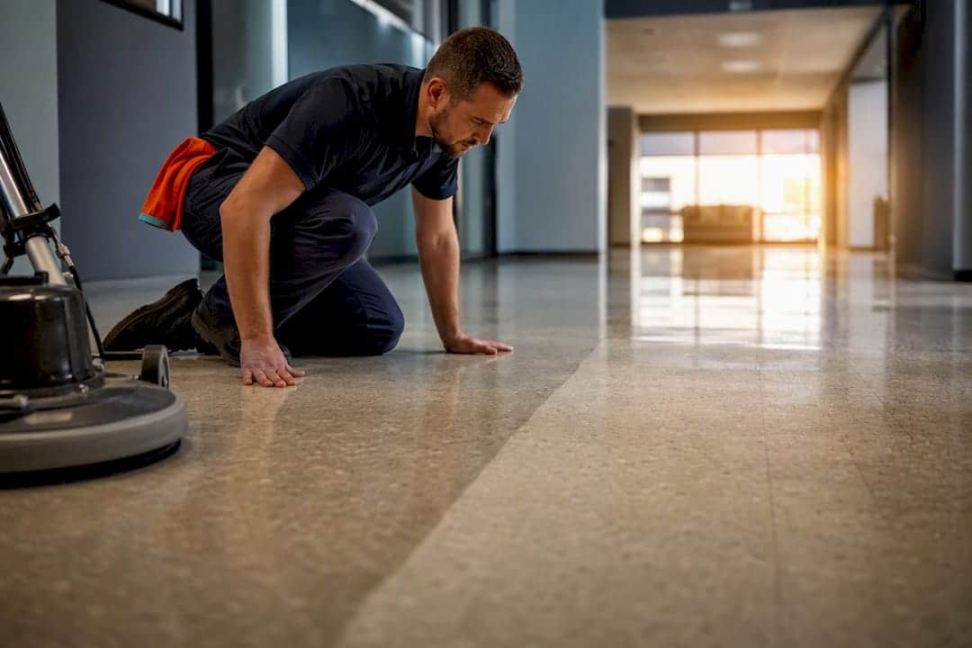 Technician inspecting a polished VCT floor