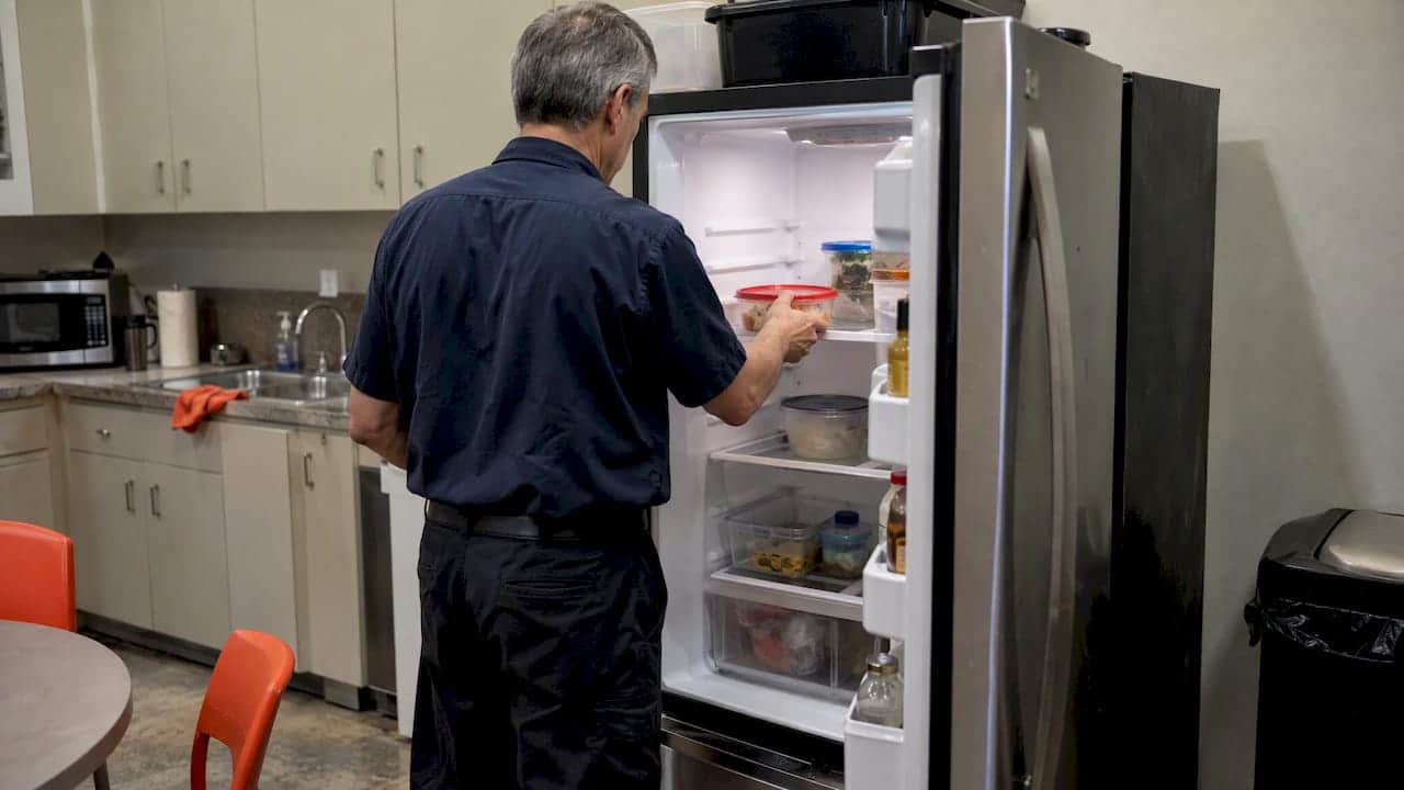Employee removing food during fridge cleanout