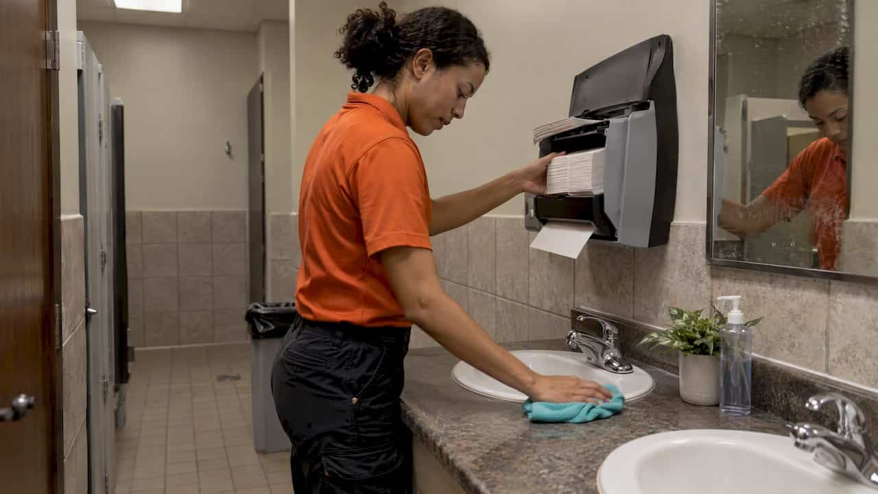 Custodian wiping a church restroom counter